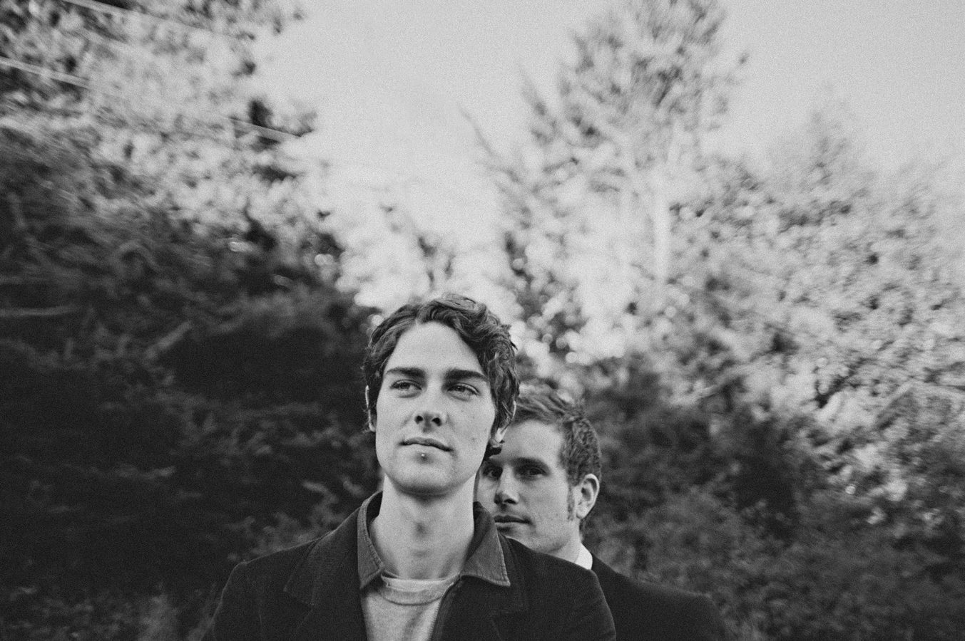 2 men, one standing behind the other, at an engagement session