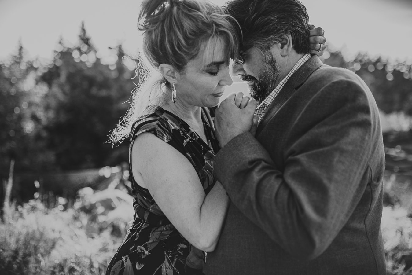 older couple intimately embracing with the sunlight behind them