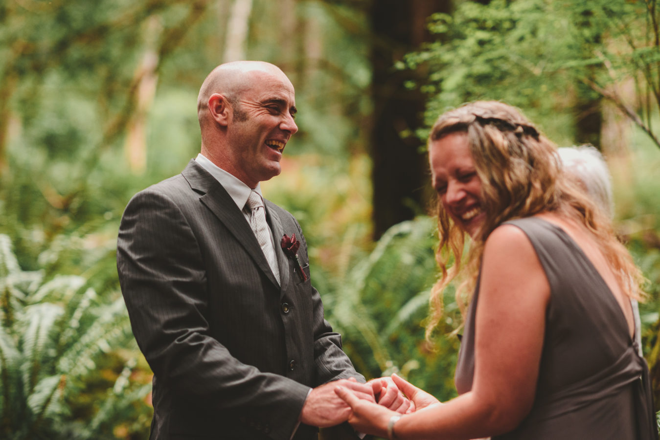 bride and groom holding hands and laughing during their wedding ceremony